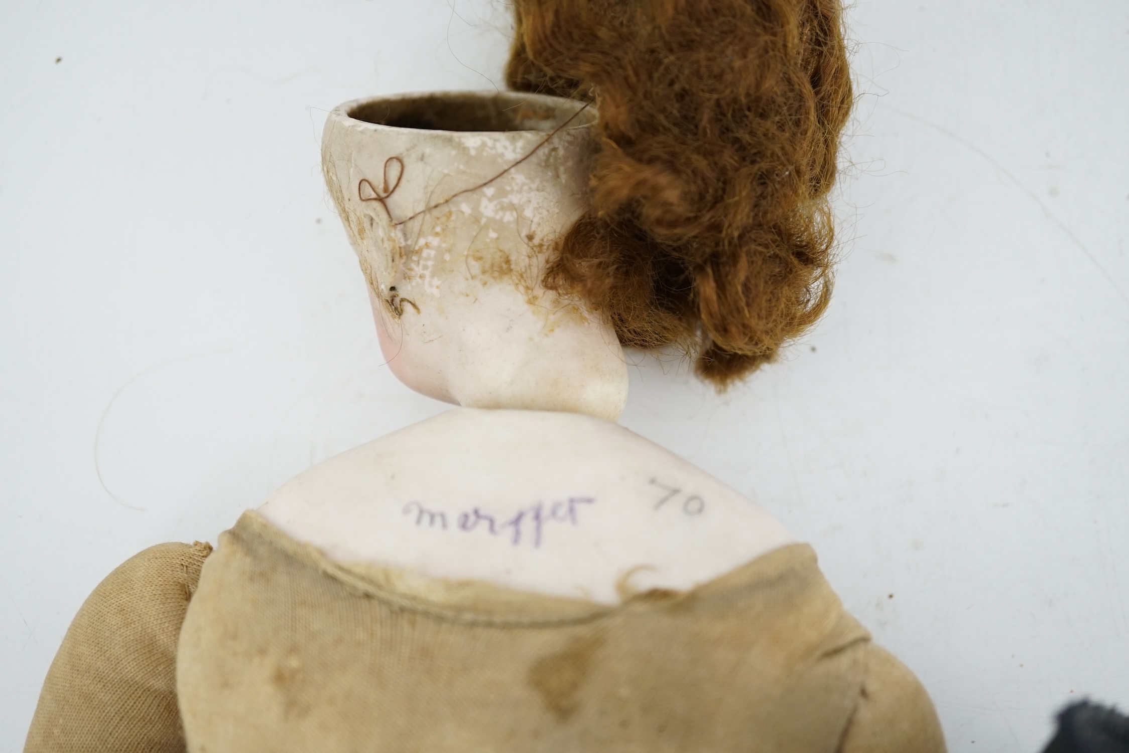 A late 19th century French biscuit head doll, possibly Simon & Halbig, with cloth body, bisque hands, 45cm high, eye and ear chip